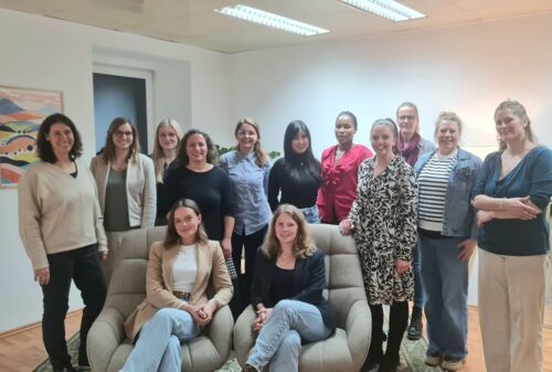 Zu sehen sind Frauen des Netzwerks in einem Raum stehend und auf zwei Sesseln sitzend